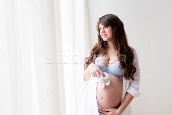 happy pregnant woman with babys bootees at home Stock photo © dolgachov