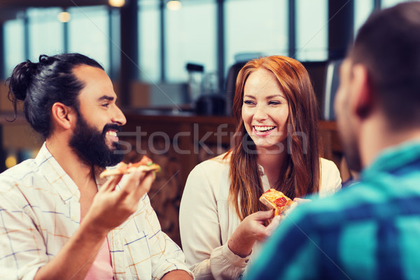Stock photo: friends eating pizza with beer at restaurant