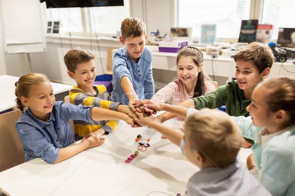 happy children holding hands at robotics school Stock photo © dolgachov