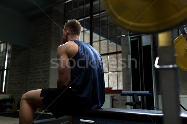 man sitting on weight bench in gym Stock photo © dolgachov