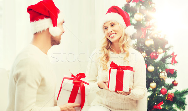 happy couple at home exchanging christmas gifts Stock photo © dolgachov
