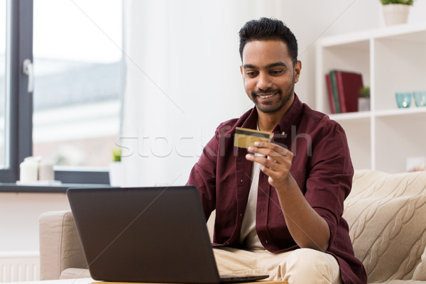 Sonriendo hombre portátil tarjeta de crédito casa tecnología Foto stock © dolgachov