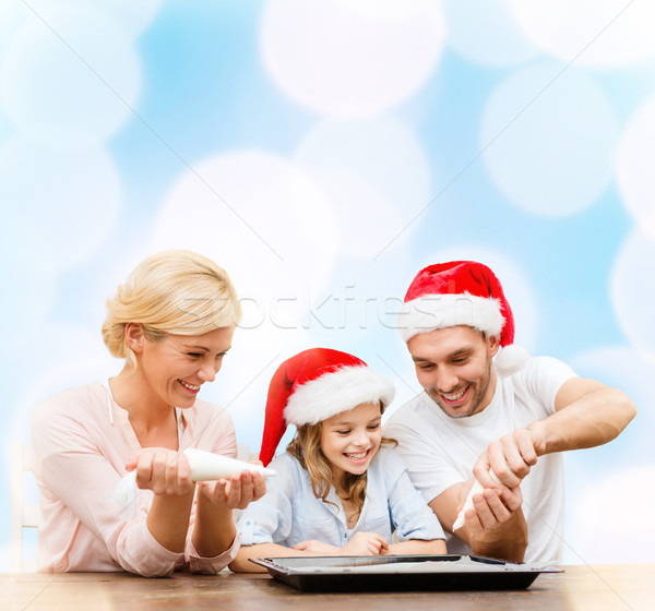 happy family in santa helper hats making cookies Stock photo © dolgachov