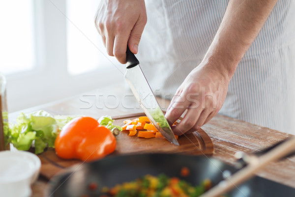 close up of male hand cutting pepper on board Stock photo © dolgachov