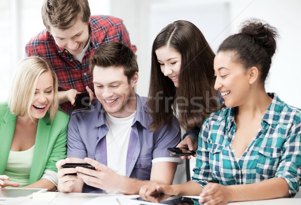 Foto d'archivio: Studenti · guardando · smartphone · scuola · istruzione · internet