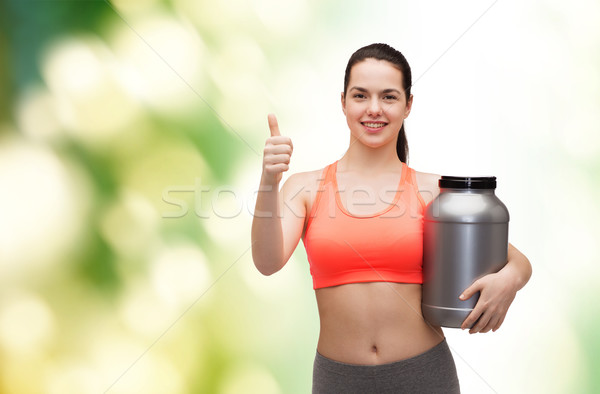 teenage girl with jar of protein showing thumbs up Stock photo © dolgachov