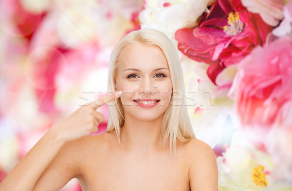 Sorridente mulher jovem indicação bochecha saúde beleza Foto stock © dolgachov