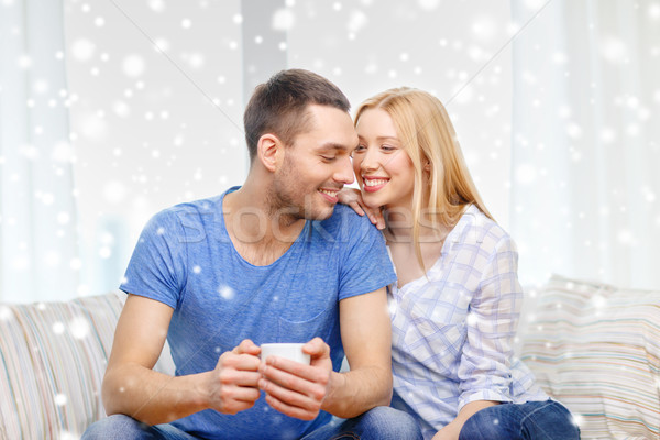 smiling couple with cup of tea or coffee at home Stock photo © dolgachov