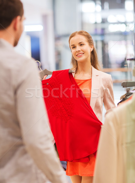 Stock photo: happy young couple choosing clothes in mall