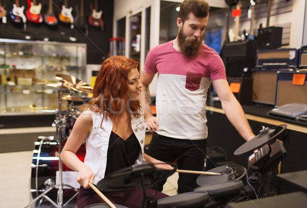 man and woman with drum kit at music store Stock photo © dolgachov