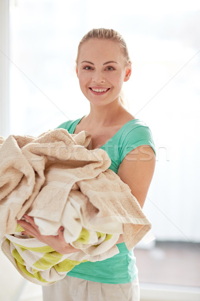 happy woman carrying clothes to laundry at home Stock photo © dolgachov