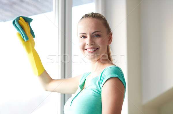 Feliz mujer guantes limpieza ventana trapo Foto stock © dolgachov