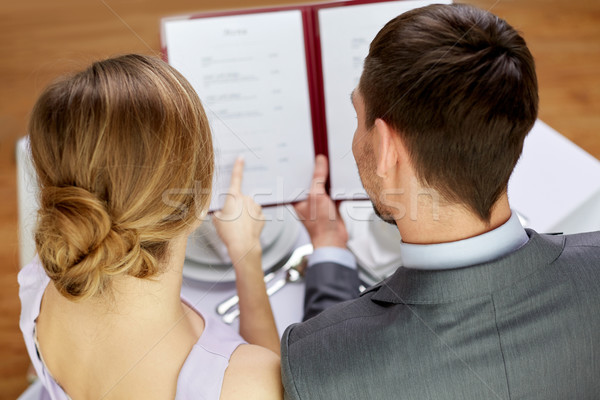 close up of happy couple with menu at restaurant Stock photo © dolgachov