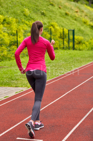 woman running on track outdoors from back Stock photo © dolgachov