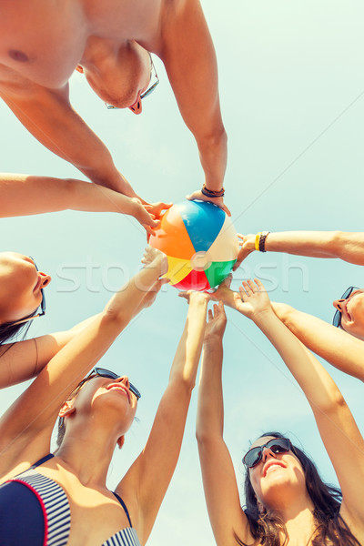 smiling friends in circle on summer beach Stock photo © dolgachov