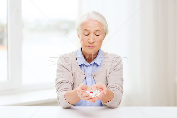 senior woman with medicine at home Stock photo © dolgachov