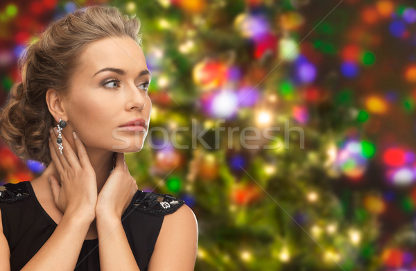 beautiful woman wearing earrings over lights Stock photo © dolgachov