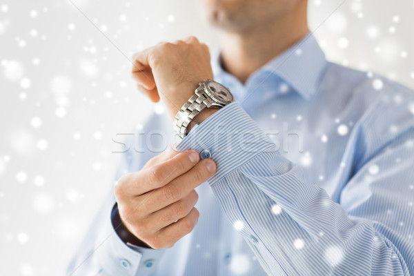 close up of man fastening buttons on shirt sleeve Stock photo © dolgachov