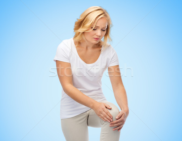 unhappy woman suffering from pain in leg Stock photo © dolgachov