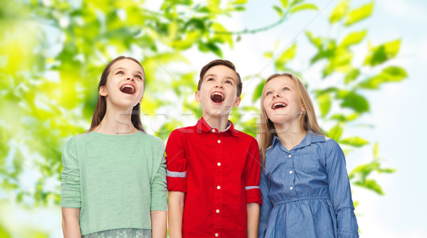 amazed boy and girls looking up Stock photo © dolgachov
