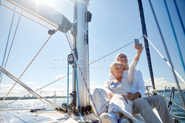 seniors with smartphone taking selfie on yacht Stock photo © dolgachov