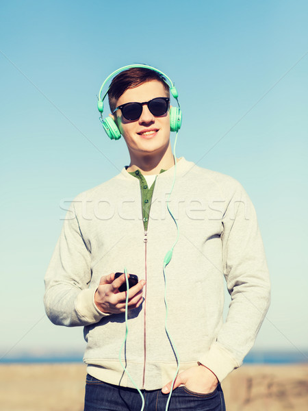 happy young man in headphones with smartphone Stock photo © dolgachov