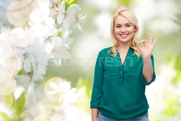 Sorridente mulher jovem camisas sinal da mão Foto stock © dolgachov