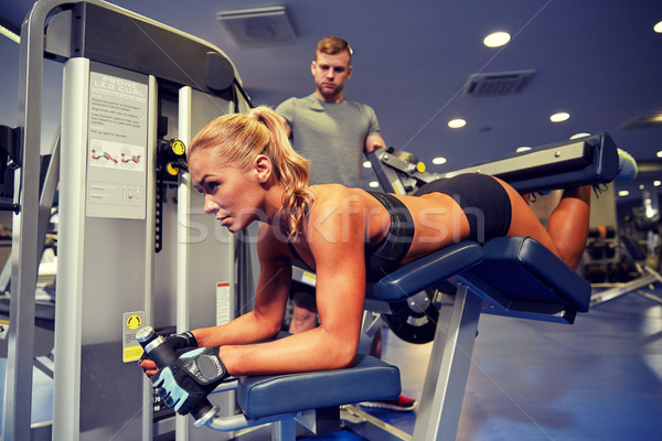 Stock photo: man and woman flexing muscles on gym machine