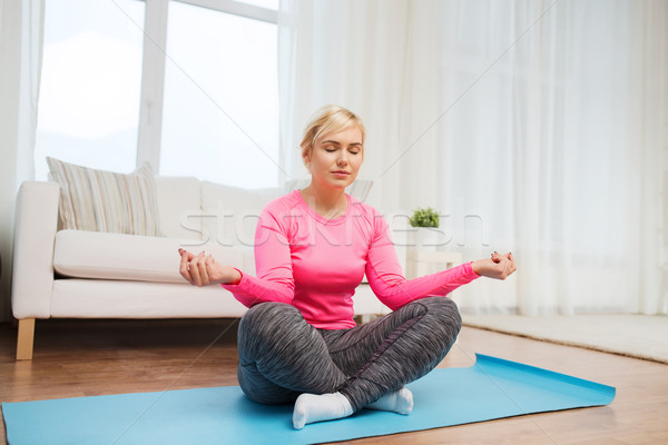 happy woman stretching leg on mat at home Stock photo © dolgachov