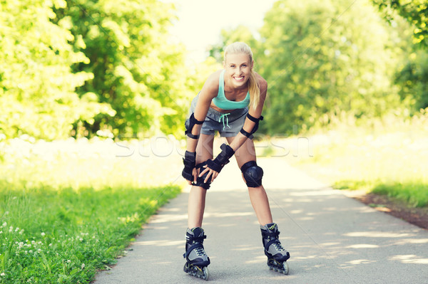 happy young woman in rollerskates riding outdoors Stock photo © dolgachov