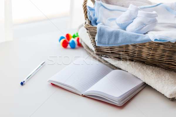 close up of baby clothes for newborn and notebook Stock photo © dolgachov