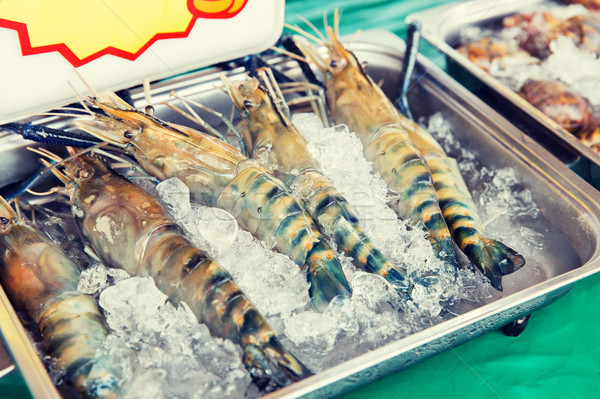 shrimps or seafood on ice at asian street market Stock photo © dolgachov