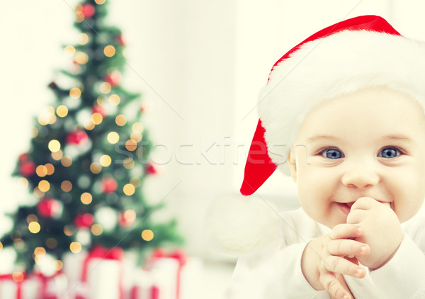 happy baby in santa hat over christmas tree lights Stock photo © dolgachov