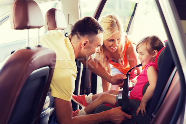 happy parents fastening child with car seat belt Stock photo © dolgachov
