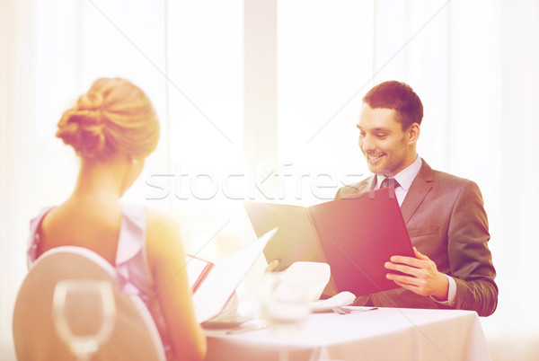 smiling young man looking at menu at restaurant Stock photo © dolgachov