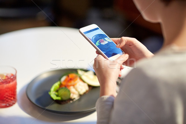 woman with smartphone photographing food at cafe Stock photo © dolgachov