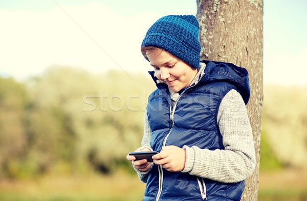 happy boy playing game on smartphone outdoors Stock photo © dolgachov