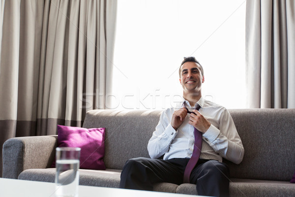 Boldog üzletember elvesz el nyakkendő hotelszoba Stock fotó © dolgachov