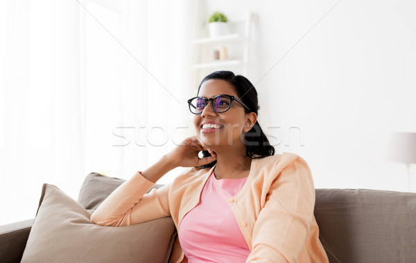 happy smiling young woman sitting on sofa at home Stock photo © dolgachov