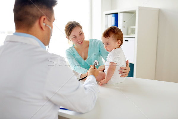doctor with stethoscope listening baby at clinic Stock photo © dolgachov