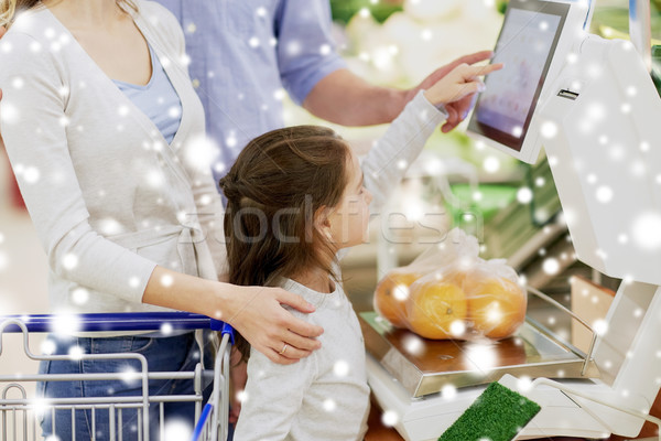 family weighing oranges on scale at grocery store Stock photo © dolgachov