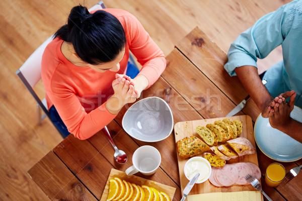 woman sitting at table and praying before meal Stock photo © dolgachov