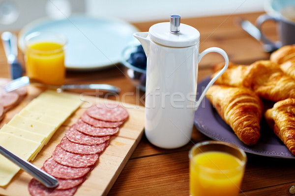 coffee pot and food on served table at breakfast Stock photo © dolgachov