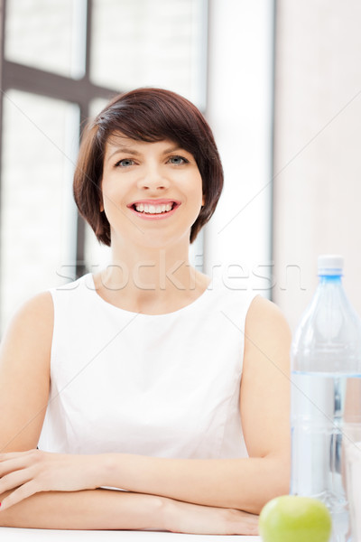 lovely housewife with green apple and bottle of water Stock photo © dolgachov