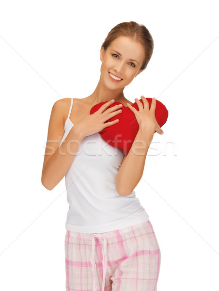 Stock photo: happy and smiling woman with heart-shaped pillow