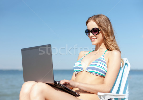 Stock photo: girl looking at tablet pc on the beach