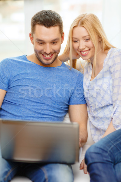 Stock photo: smiling happy couple with laptop at home
