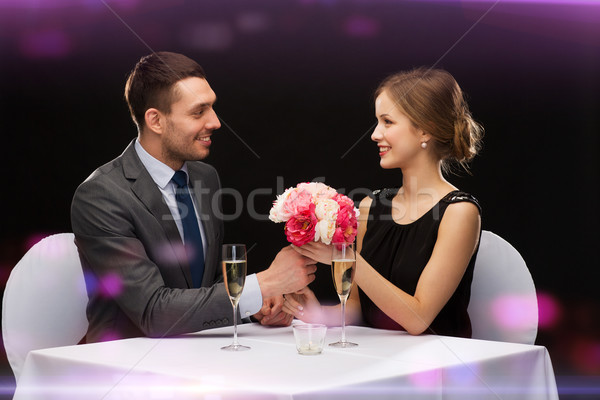 smiling man giving flower bouquet to woman Stock photo © dolgachov