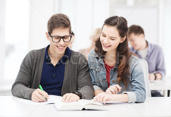 two teenagers with notebooks and book at school Stock photo © dolgachov