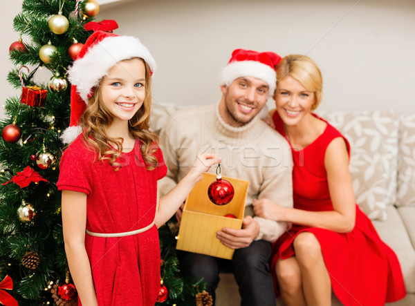 smiling family decorating christmas tree Stock photo © dolgachov